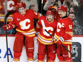 Útočník Blake Coleman (center) oslavuje svoj gól so spoluhráčmi Samom Honzekom (vľavo) a Mikaelom Backlundom (vpravo).