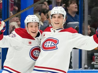 Ivan Demidov (vľavo) sa teší z gólu, ktorý strelil slovenský hokejista a jeho spoluhráč Juraj Slafkovský (vpravo) v zápase zámorskej NHL Tampa Bay Lightning - Montreal Canadiens.