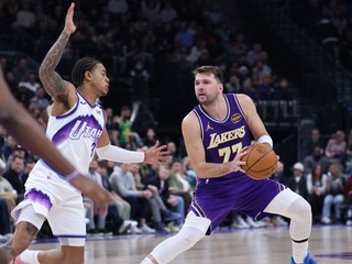 Rozohrávač Los Angeles Lakers Luka Dončić (77) s krokom kroku späť a strieľa, zatiaľ čo ho bráni rozohrávač Utah Jazz Keyonte George (vľavo).