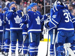 Brankár Toronta Maple Leafs Dennis Hildeby (vpravo) ktorému gratulujú spoluhráči k čistému kontu