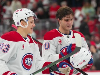Vpravo slovenký útočník Juraj Slafkovský v drese Montrealu (20) a Ivan Demidov (93) oslavujú víťazstvo proti Caroline.