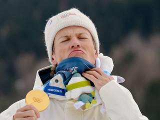 Nórsky bežec na lyžiach Johannes Hösflot Kläbo pózuje na pódiu so zlatou medailou.