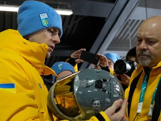 Ukrajinský skeletonista Vladislav Heraskevič drží svoju prilbu s vyobrazenými ukrajinskými športovcami.