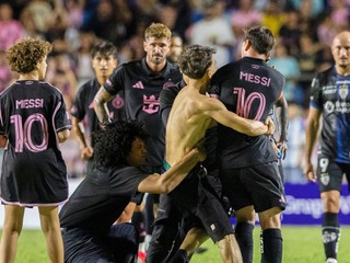 Fanúšik, ktorý sa dostal na ihrisko, chytá hráča Lionela Messiho z Interu Miami na konci prípravného futbalového zápasu.