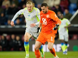 Martin Dúbravka odkopáva loptu pred napádajúcim Erlingom Haalandom. 