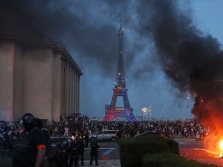 Auto horí a ohňostroj exploduje po tom, čo fanúšikovia Paríža St. Germain oslavujú obhajobu titulu pred Eiffelovou vežou v Paríži po finálovom dueli Ligy majstrov.