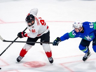 Na snímke hráč Kanady John Tavares (vľavo) a hráč Slovinska Matic Török bojujú o puk počas zápasu.
