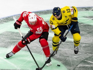 Tim Berni (vľavo) a hráč Švédska Lucas Raymond bojujú o puk počas štvrťfinálového zápasu Švajčiarsko - Švédsko.