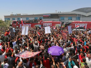 Fanúšikovia vítajú egyptskú futbalovú reprezentáciu po jej prílete na letisko El Alamein.