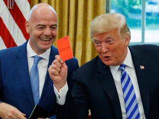 Prezident Donald Trump drží v ruke červenú kartu počas stretnutia s prezidentom FIFA Giannim Infantinom v Oválnej pracovni Bieleho domu v utorok 28. augusta 2018 vo Washingtone.