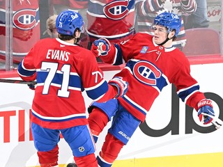 Hokejista Montrealu Canadiens Jake Evans (71) sa teší z víťazného gólu, ktorý strelil jeho spoluhráč Cole Caufield (13).