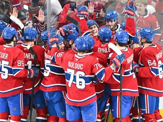 Slovenský hokejista Montrealu Canadiens Juraj Slafkovský (20) sa teší so spoluhráčmi z víťazného gólu, ktorý strelil Cole Caufield v predĺžení.