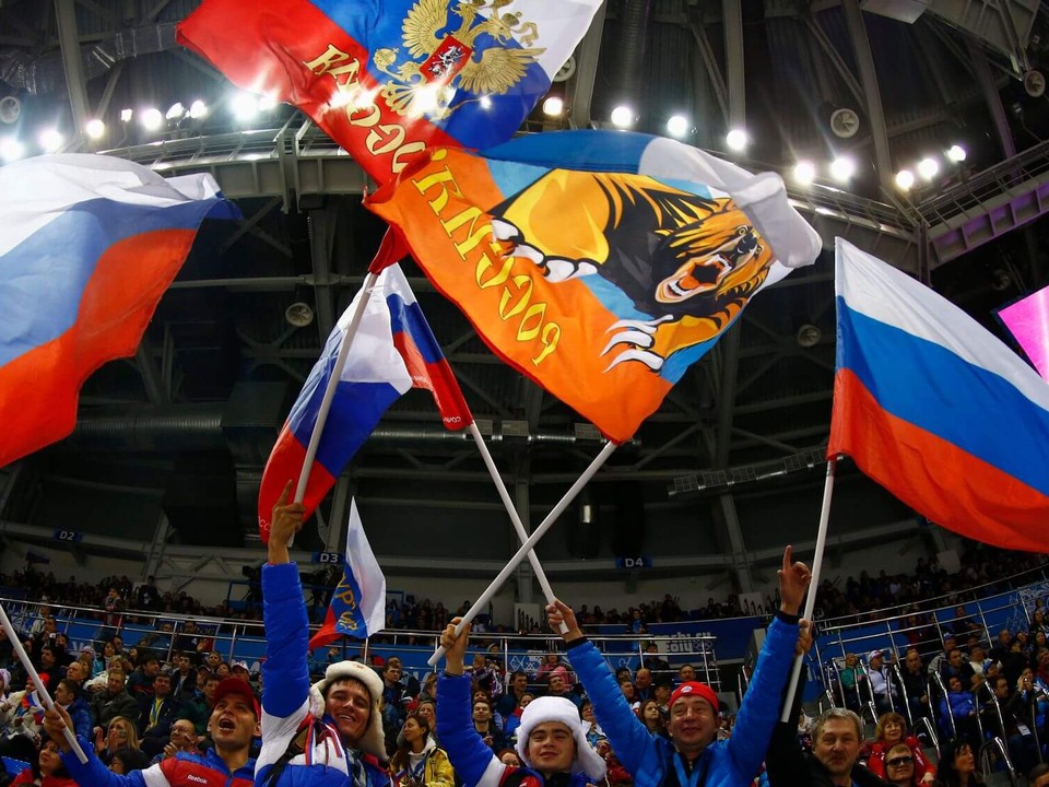 Hokejoví fanúšikovia s ruskými vlajkami na zimných hrách v Soči 2014. 