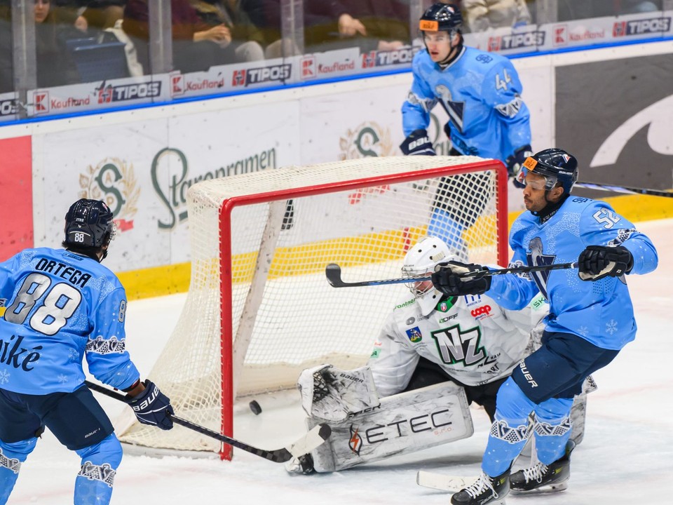 Zľava Austin Ryan Ortega (Slovan), Roman Rychlík (Nové Zámky) a Sena Wendell Acolatse (Slovan) počas gólu počas 33. kola Tipos extraligy HC Slovan Bratislava - HC Nové Zámky.