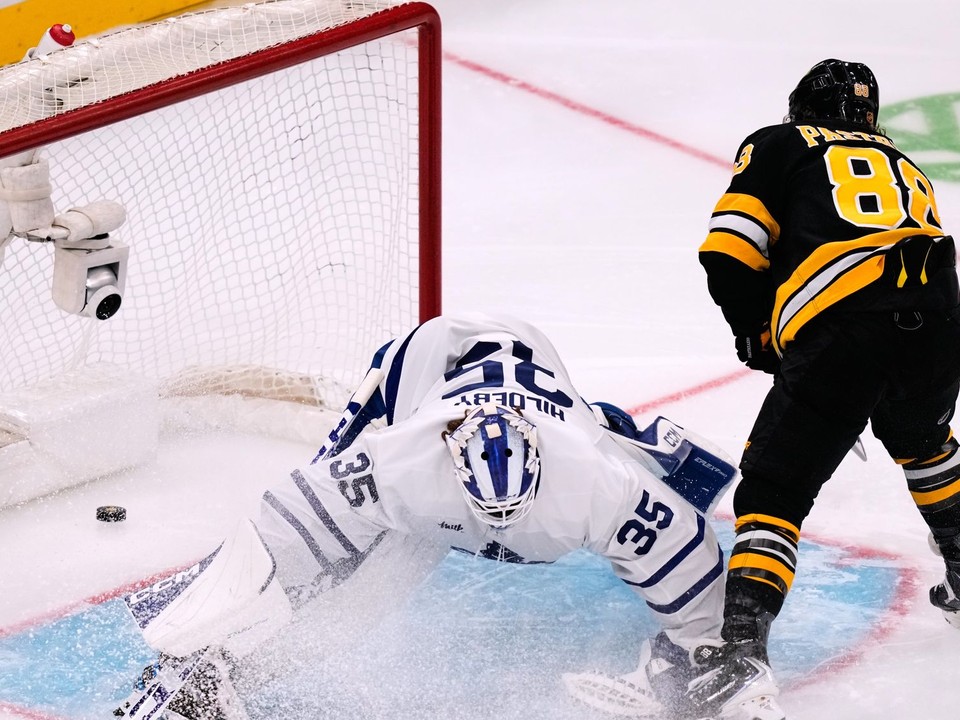 Na snímke brankár Toronta Maple Leafs Dennis Hildeby, ktoré prekonáva hokejista Bostonu Bruins David Pastrňák a strelia svoj 400. gól v kariére.