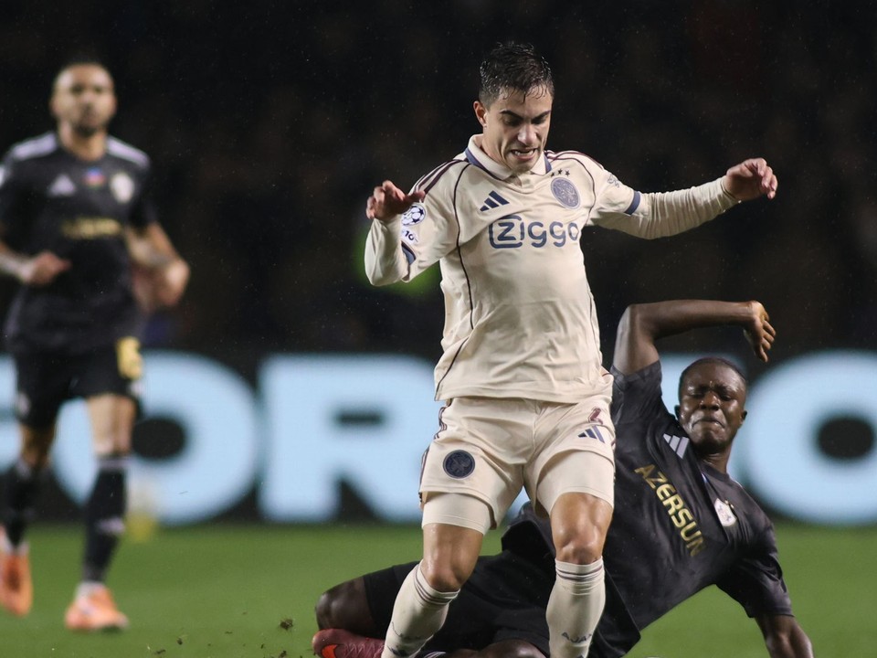 Hráč Ajaxu Lucas Rosa a hráč Qarabagu Emmanuel Addai bojujú o loptu počas zápasu.