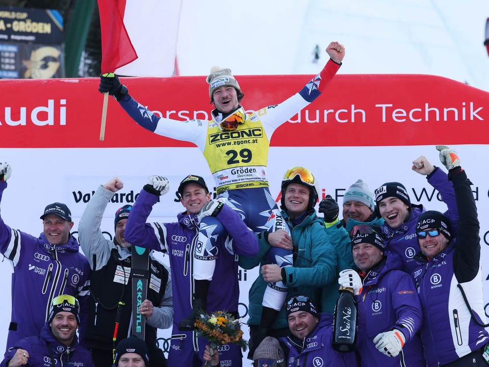 Český lyžiar Jan Zabystřan (hore uprostred) oslavuje na pódiu so svojím tímom po jeho víťazstve pretekov super-G Svetového pohára mužov v talianskej Val Gardene.