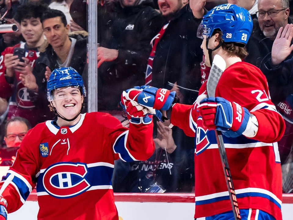 Juraj Slafkovský (vpravo) a jeho spoluhráč Cole Caufield sa radujú z gólu.