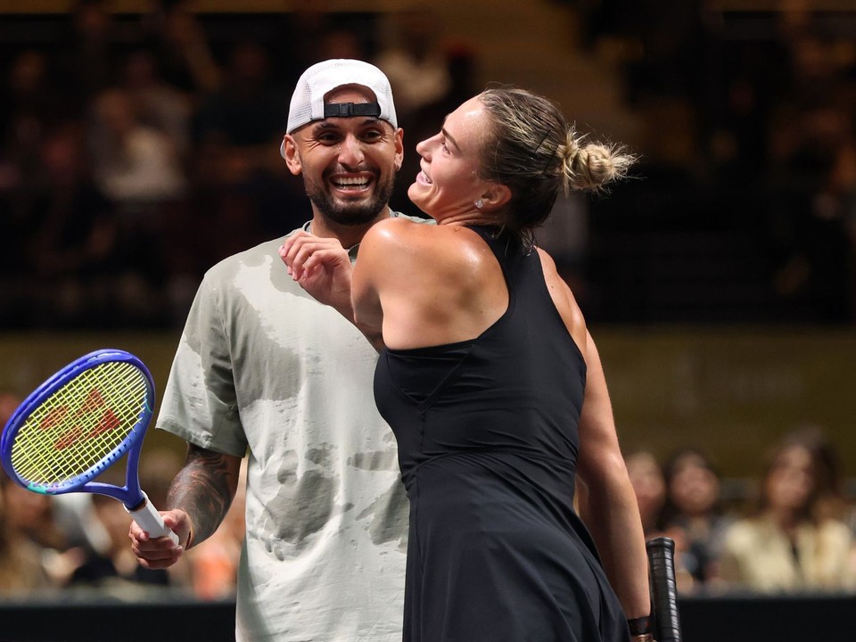Nick Kyrgios (vľavo) a Aryna Sabalenková si podávajú ruky pri sieti počas zápasu.