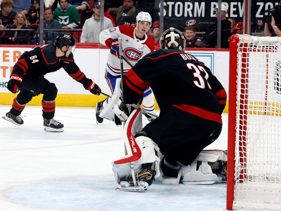 Hráč Montrealu Canadiens Juraj Slafkovský (20) strieľa gól, keď prekonáva brankára Caroliny Hurricanes Brandona Bussiho (32).