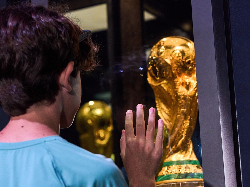 Mladý chlapec pozerá na trofej pre víťaza MS.