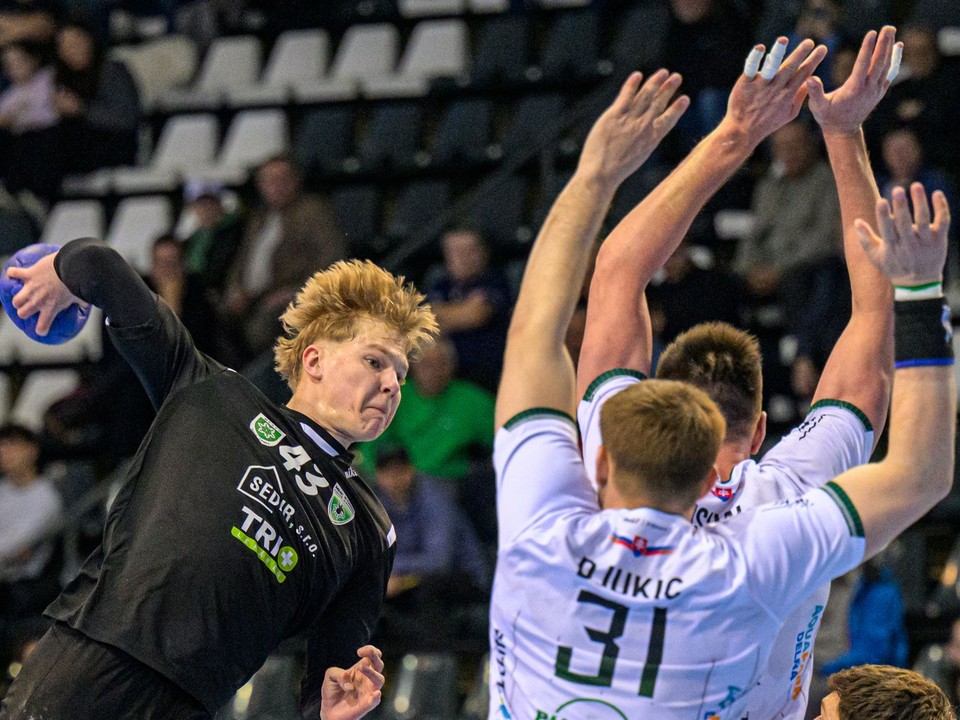 Vľavo Samuel Valent (Nové Zámky) strieľa cez hráčov Prešova počas zápasu 4. kola nadstavbovej časti Niké handball extraligy Tatran Prešov - MHC ŠTART Nové Zámky.