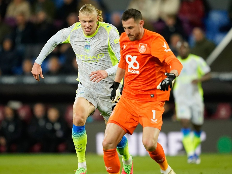 Martin Dúbravka odkopáva loptu pred napádajúcim Erlingom Haalandom. 