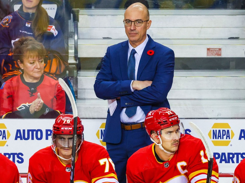 Tréner Calgary Ryan Huska, vľavo dole slovenský útočník Martin Pospíšil. 