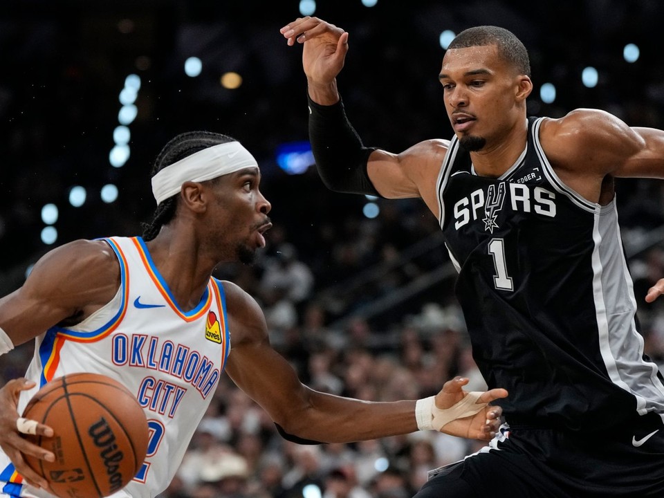 Rozohrávač tímu Oklahoma City Thunder Shai Gilgeous-Alexander (2) preniká popri krídelníkovi tímu San Antonio Spurs Victorovi Wembanyamovi (1).