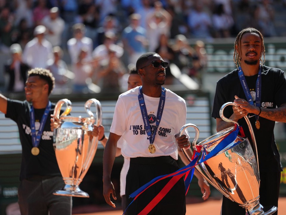 Ousmane Dembélé z PSG (vľavo) a Bradley Barcola prichádzajú na kurt s trofejou Ligy majstrov počas turnaja Roland Garros v Paríži.