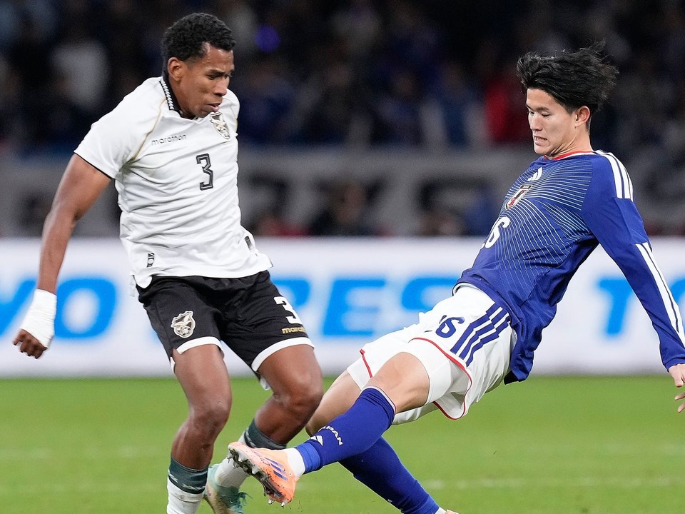 Na archívnej snímke z 18. novembra 2025 futbalista Bolívie Diego Medina (vľavo) a hráč Japonska Keisuke Goto bojujú o loptu v prípravnom dueli Japonsko - Bolívia v Tokiu.