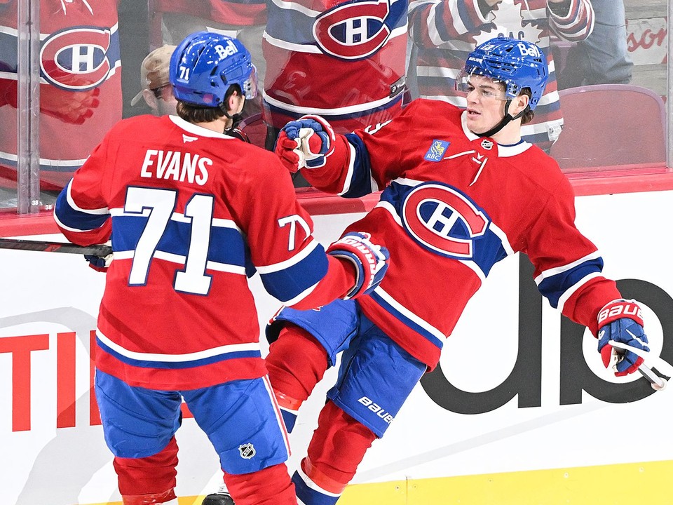 Hokejista Montrealu Canadiens Jake Evans (71) sa teší z víťazného gólu, ktorý strelil jeho spoluhráč Cole Caufield (13).