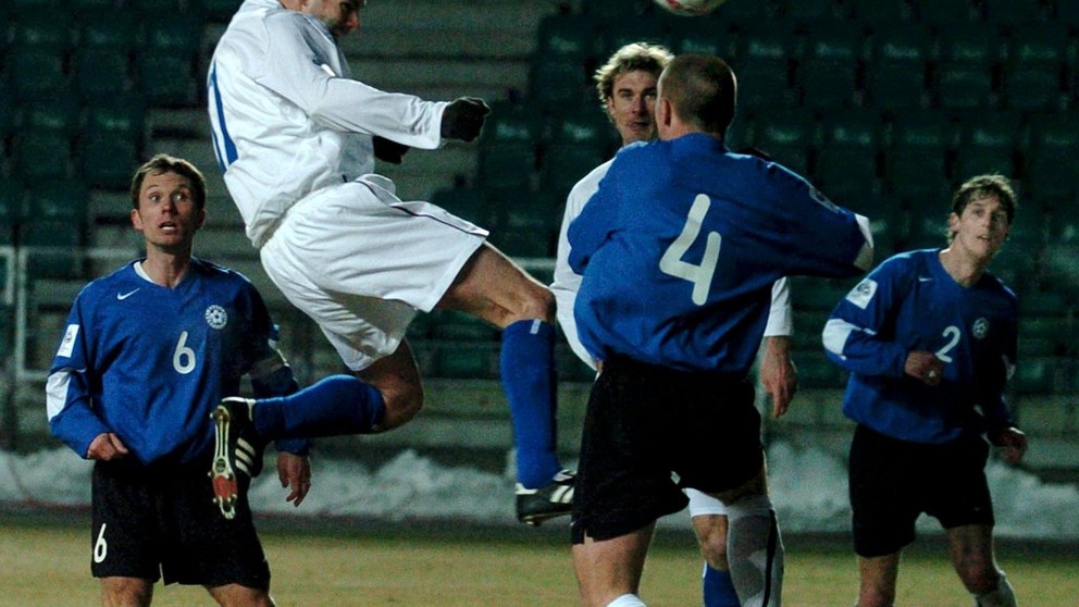 Ľubomír Reiter (v bielom vo výskoku) strieľa druhý gól do estónskej siete, akciu sledujú Martin Reim (č.6) a Enar Jaager (č.4). Snímka z kvalifikačného zápase o postup na MS 2006 Estónsko - Slovensko 1:2 (26.3.2005, Tallinn).