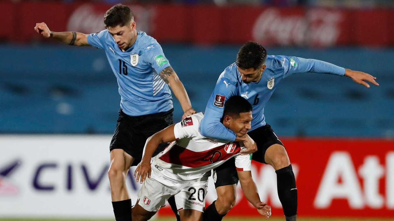 Edison Flores z Peru (v strede), v súboji s hráčmi Uruguaja: Rodrigo Bentancur (vpravo) a Federico Valverde.