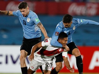 Edison Flores z Peru (v strede), v súboji s hráčmi Uruguaja: Rodrigo Bentancur (vpravo) a Federico Valverde.