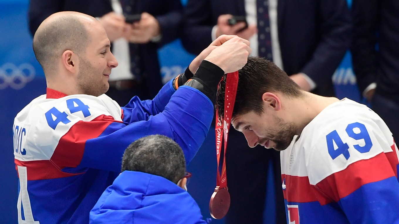 Mislav Rosandič dáva Samuelovi Takáčovi bronzovú medailu na ZOH 2022 v Pekingu.
