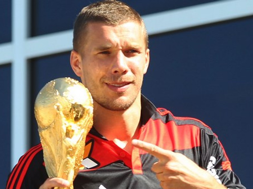 Nemecký futbalista Lukas Podolski drží trofej 14. júla 2014 v Riu de Janeiro. Nemecko zvíťazilo vo finále MS nad Argentínou 1:0 po predĺžení.