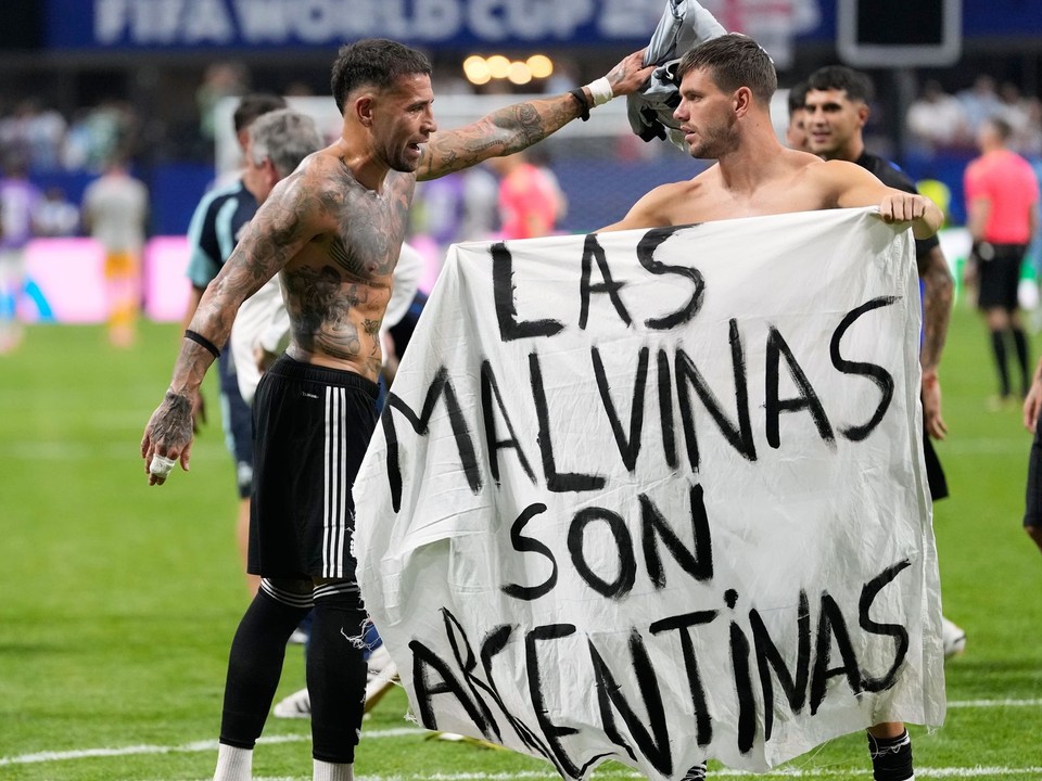 Giovani Lo Celso drží transparent o Falklandských ostrovoch s nápisom „Malvíny patria Argentíne“.