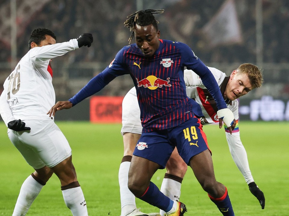 Yan Diomande z Lipska (uprostred) bojuje o loptu s Ericom Smithom zo St. Pauli (vpravo)