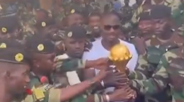 Tréner Senegalu s trofejou medzi vojakmi.