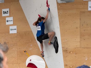 Diváci sledujú súťažiacu 
v športovom lezení v disciplíne boulder.