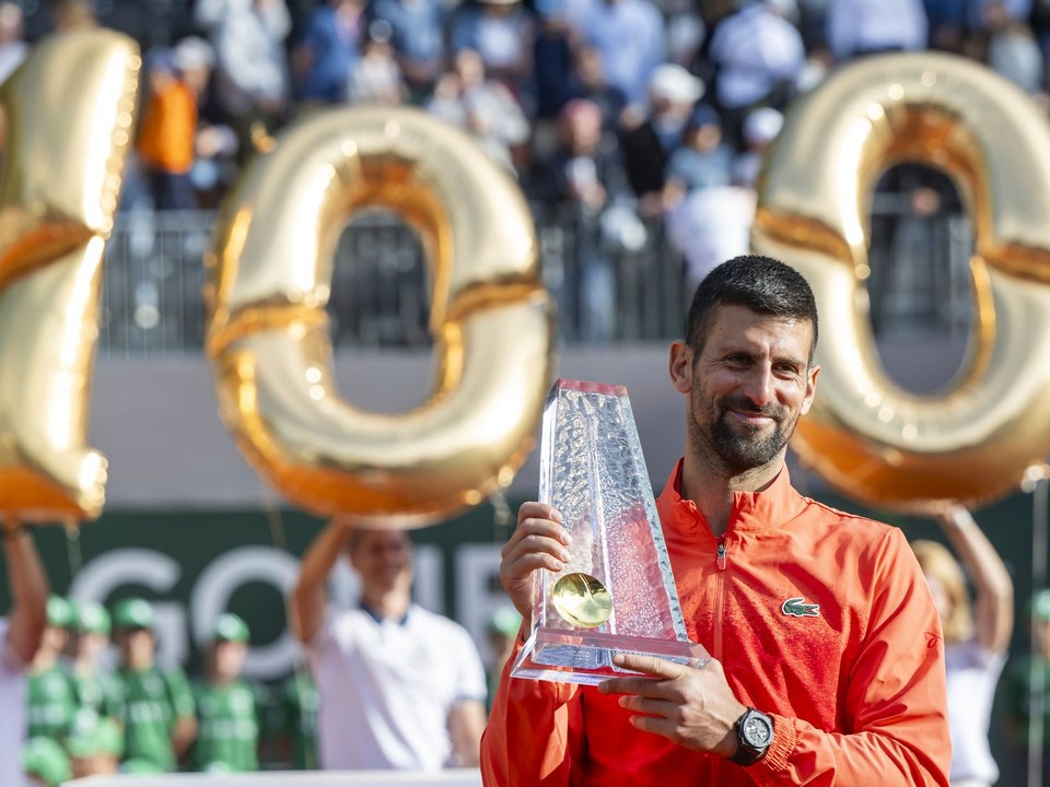 Novak Djokovič pózuje so 100. trofejou na okruhu ATP.