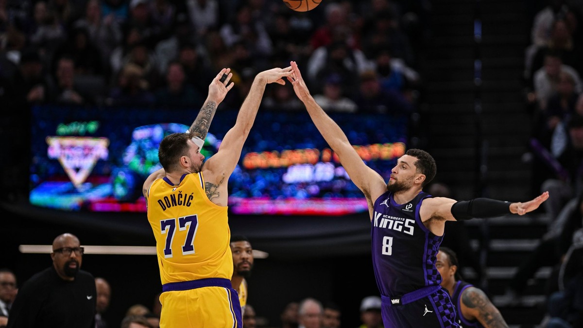 Luka Dončič (77) z Los Angeles Lakers strieľa cez rozohrávača Zacha LaVinea (8) zo Sacramenta.