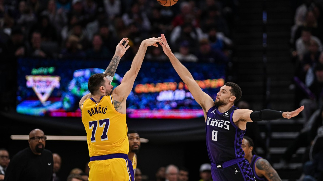 Luka Dončič (77) z Los Angeles Lakers strieľa cez rozohrávača Zacha LaVinea (8) zo Sacramenta.