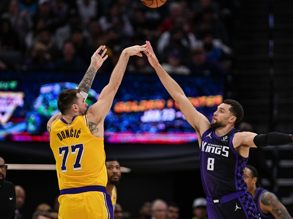 Luka Dončič (77) z Los Angeles Lakers strieľa cez rozohrávača Zacha LaVinea (8) zo Sacramenta.