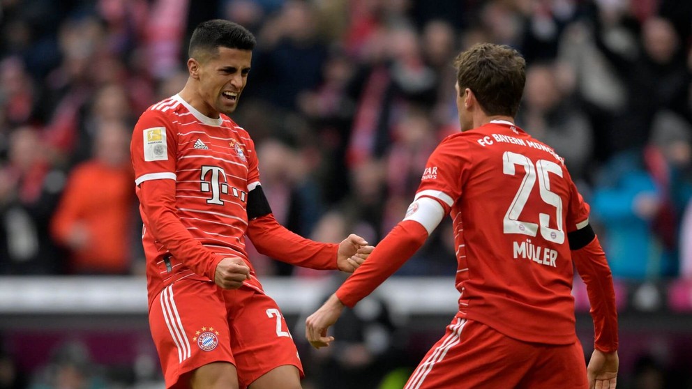 Futbalisti Bayernu Mníchov Joao Cancelo (vľavo) a Thomas Müller sa tešia po strelenom góle. 