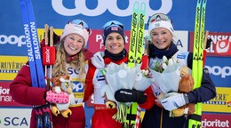 Víťazná nórska bežkyňa na lyžiach Heidi Wengová (uprostred) pózuje na pódiu s druhou Američankou Jessicou Digginsovou (vľavo) a treťou Švédkou Fridou Karlssonovou (vpravo).