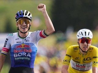 Belgický cyklista Remco Evenepoel (vľavo) oslavuje v cieli pred Slovincom Tadejom Pogačarom v žltom drese.