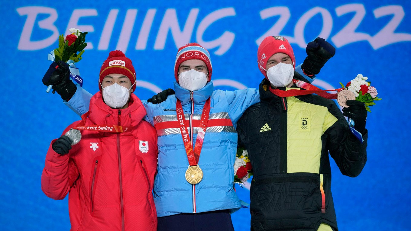 Nórsky skokan na lyžiach Marius Lindvik (uprostred) pózuje so zlatou olympijskou medailou počas medailovej ceremónie po triumfe na veľkom mostíku v stredisku Čang-ťia-kchou na ZOH 2022 v Pekingu.