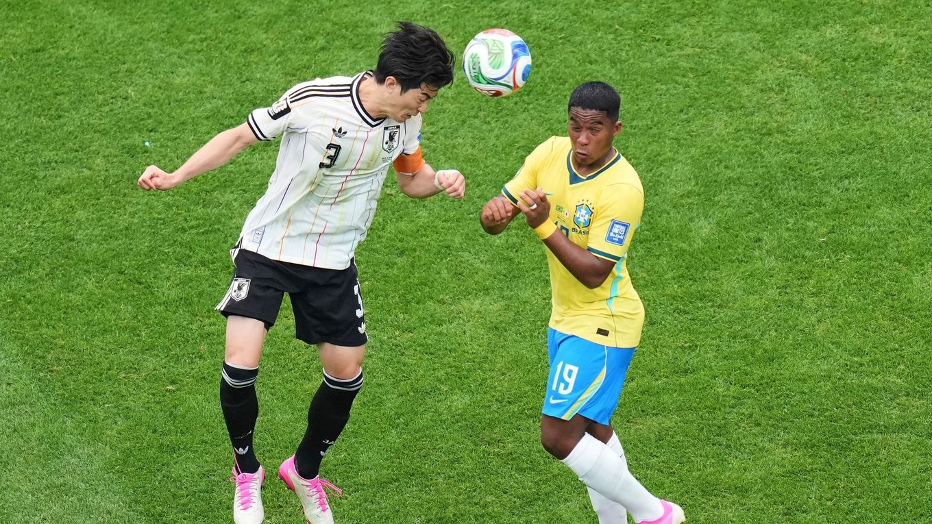 Japonec Shogo Taniguchi (3), vľavo, sa vrhá po lopte spolu s Brazílčanom Endrickom (19)